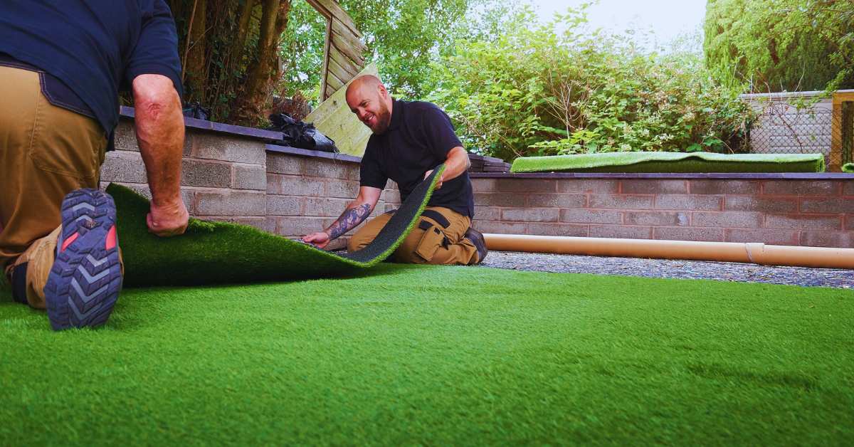 two carpet installers installing fake grass carpet