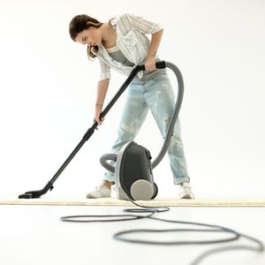 A woman vacuuming carpet